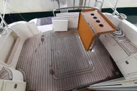 Spacious Sas-Vektor 950 boat deck with wooden flooring and foldable table, 2015 model.