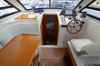Interior of 2015 Sas-Vektor 950 boat with steering wheel and seating area.