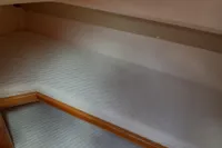 Cozy cabin interior of 2015 Sas-Vektor 950 boat with wooden accents and bedding.