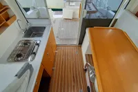 Interior of 2015 Sas-Vektor 950 boat with kitchen and wooden flooring.
