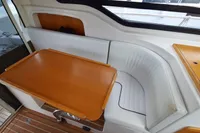 Interior of 2015 Sas-Vektor 950 boat with wooden table and white seating.