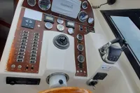 Control panel of 2015 Sas-Vektor 950 boat with wooden steering wheel and navigation instruments.
