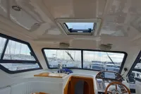 Interior of a 2015 Sas-Vektor 950 boat with wooden accents and steering wheel.