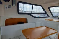 Interior of 2015 Sas-Vektor 950 boat with wooden table and seating area.