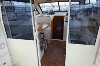Interior view of 2015 Sas-Vektor 950 boat with wooden flooring and sliding glass doors.