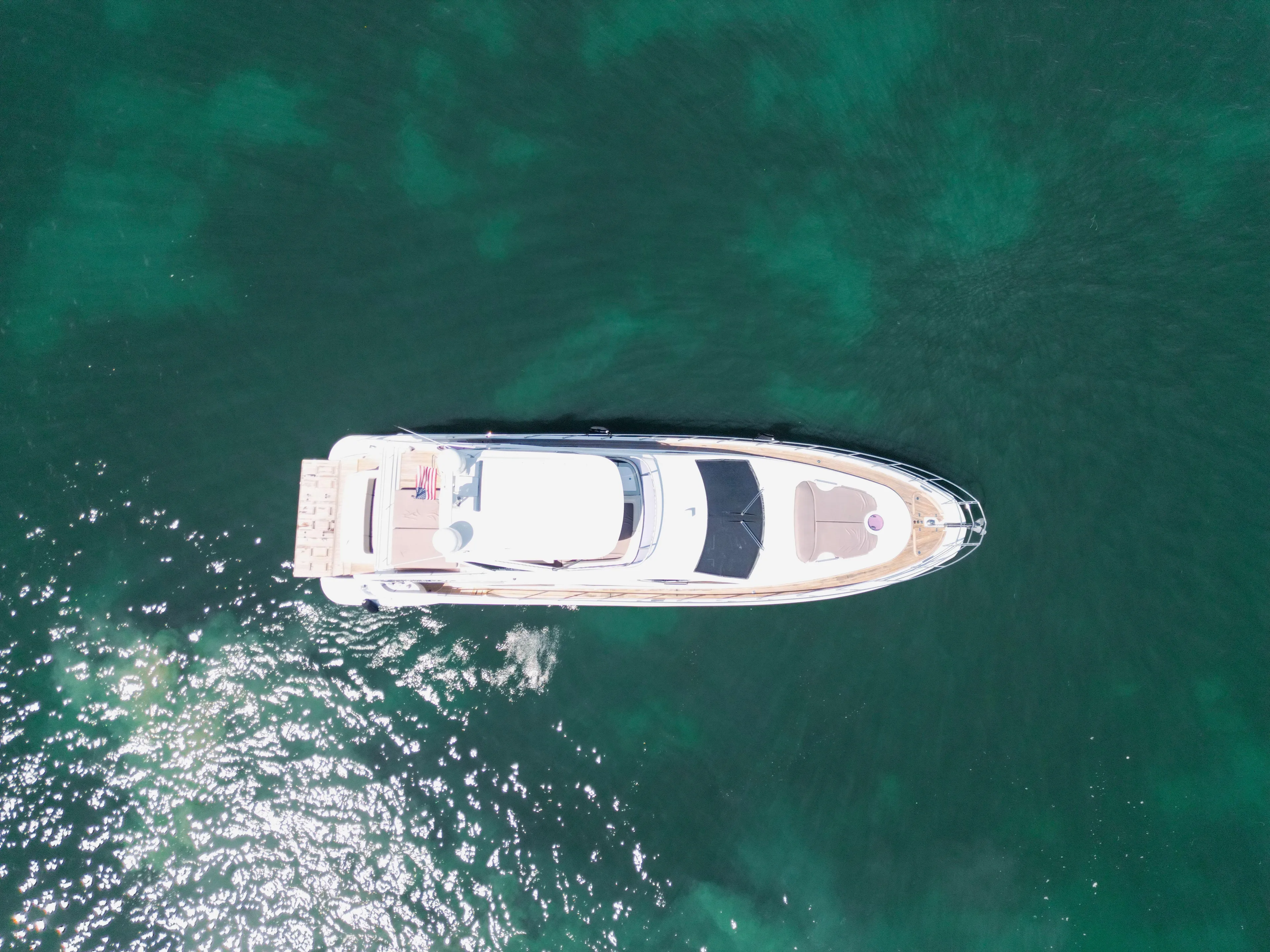 Prime Time II Yacht Photos Pics Aerial view of 2016 Azimut 64 Flybridge yacht on clear green water.