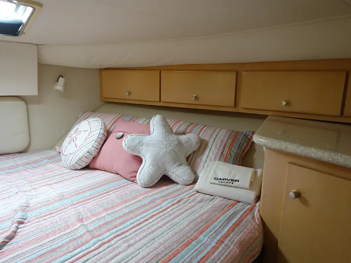  Yacht Photos Pics Cozy bedroom in 2000 Carver 406 Aft Cabin Motor Yacht with striped bedding and decorative pillows.