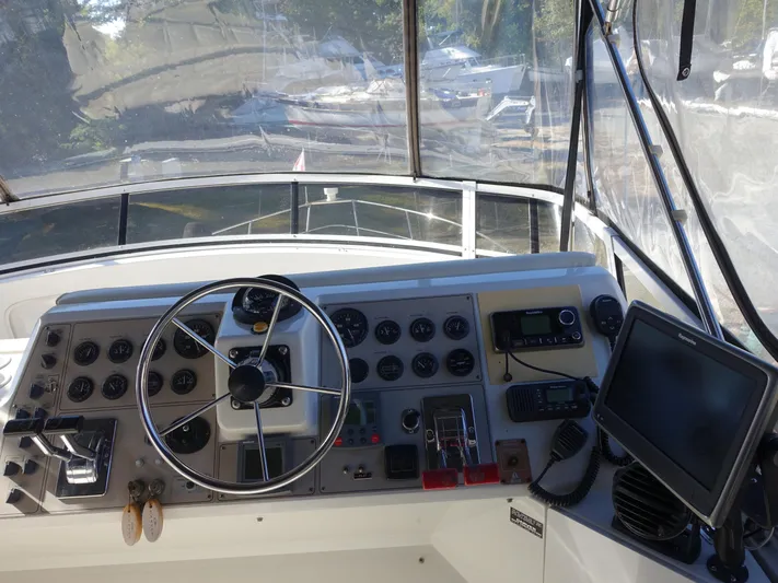  Yacht Photos Pics Helm of 2000 Carver 406 Aft Cabin Motor Yacht with steering wheel and navigation controls.