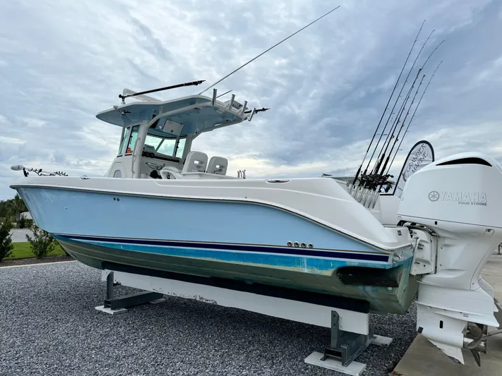 Yacht Photos Pics 2008 Everglades 320CC boat with fishing rods, displayed on gravel.