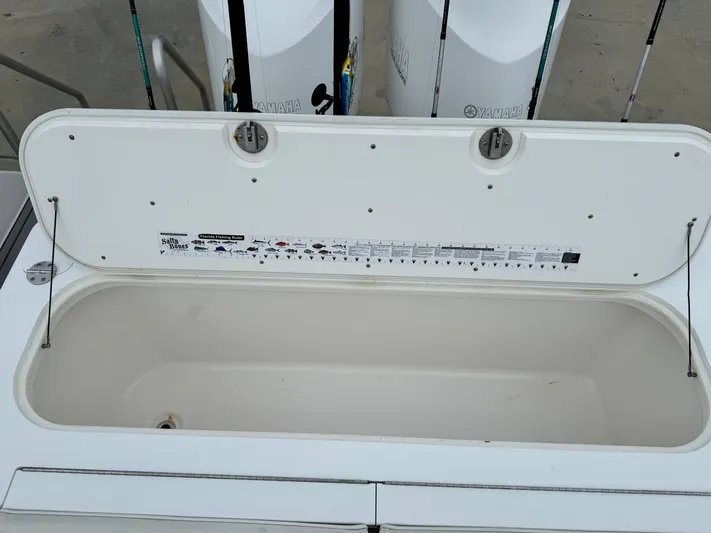  Yacht Photos Pics Open storage compartment on a 2008 Everglades 320CC boat with fishing rods in the background.