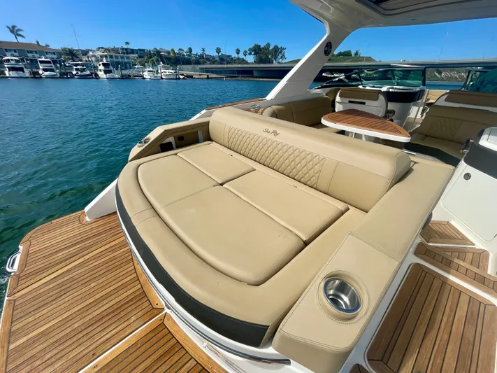 Honey Yacht Photos Pics Luxurious 2019 Sea Ray SLX 310 boat interior with tan seating and wooden deck.