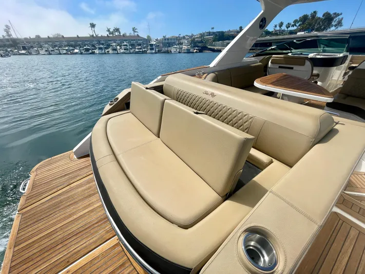 Honey Yacht Photos Pics 2019 Sea Ray SLX 310 boat with luxurious seating and wooden deck, docked in a marina.