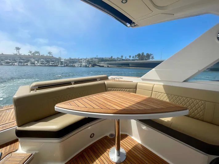 Honey Yacht Photos Pics 2019 Sea Ray SLX 310 boat interior with elegant seating and wooden table, overlooking marina.