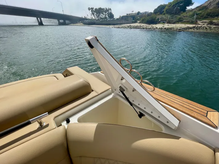 Honey Yacht Photos Pics 2019 Sea Ray SLX 310 boat with open storage compartment, near a bridge and shoreline.