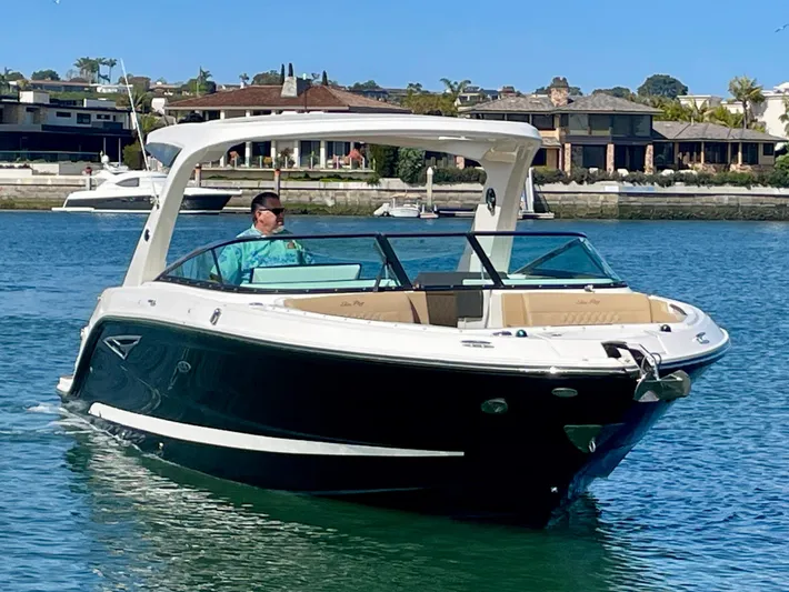 Honey Yacht Photos Pics 2019 Sea Ray SLX 310 boat cruising on a sunny day in a scenic waterfront area.