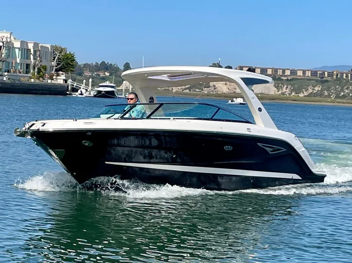 Honey Yacht Photos Pics 2019 Sea Ray SLX 310 boat cruising on a sunny day in a scenic harbor.