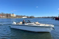 2020 Nimbus T8 boat cruising on a calm river under a clear blue sky.