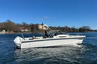 2020 Nimbus T8 boat cruising on a calm lake under a clear blue sky.