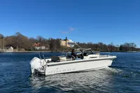 Nimbus T8 2020 boat cruising on a calm lake under a clear blue sky.