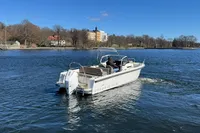 Nimbus T8 boat cruising on a calm lake under a clear blue sky, 2020 model.