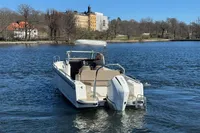 Nimbus T8 2020 boat cruising on a calm lake with scenic shoreline in the background.