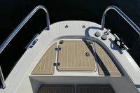 Deck of 2020 Nimbus T8 boat with stainless steel railings and wooden flooring.