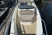 2020 Nimbus T8 boat with beige seating, docked on calm water.