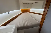 Cozy cabin interior of 2020 Nimbus T8 boat with cushioned bed and wooden accents.