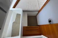 Interior view of 2020 Nimbus T8 boat cabin with wooden flooring and cushioned seating.