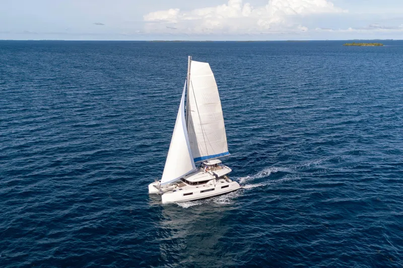 Bellissima Yacht Photos Pics 2024 Lagoon 51 catamaran sailing on open ocean under clear skies.