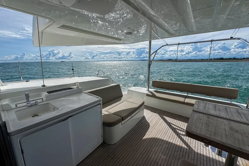 Bellissima Yacht Photos Pics Luxurious 2024 Lagoon 51 yacht interior with ocean view, featuring seating and kitchenette.