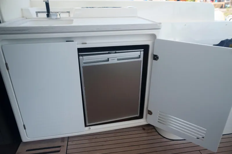 Bellissima Yacht Photos Pics 2024 Lagoon 51 yacht kitchenette with open cabinet and compact fridge.