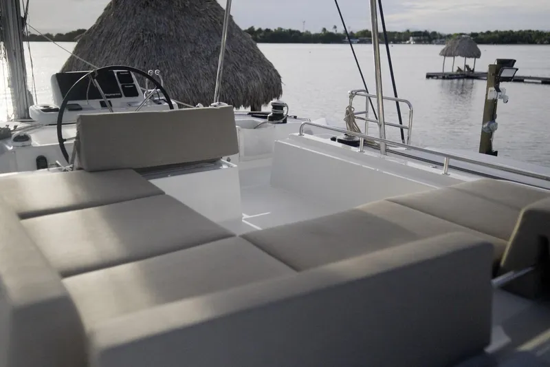 Bellissima Yacht Photos Pics 2024 Lagoon 51 yacht interior with cushioned seating, overlooking serene waters.