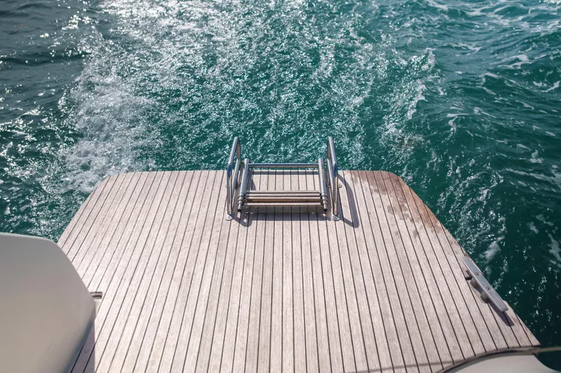 Bellissima Yacht Photos Pics Stern view of 2024 Lagoon 51 yacht with swim platform and ocean waves.