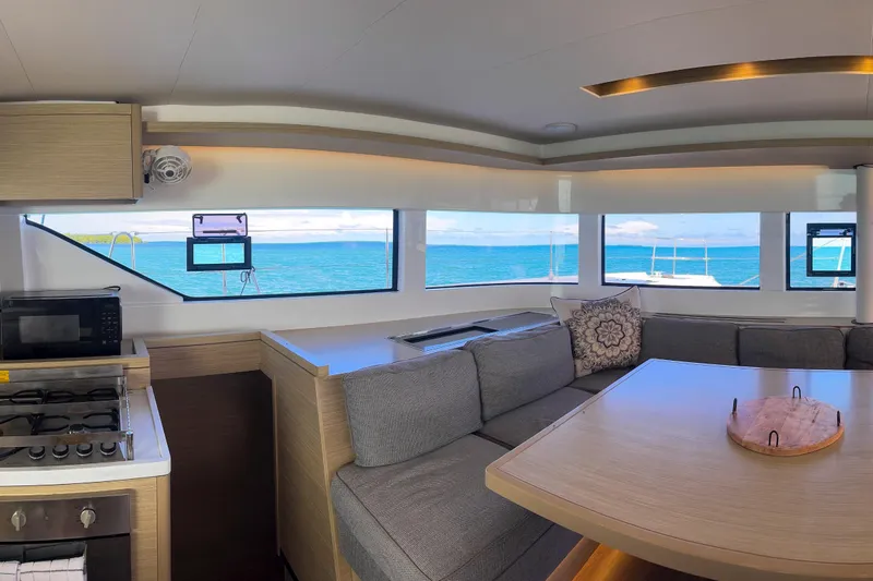 Bellissima Yacht Photos Pics Interior of 2024 Lagoon 51 catamaran with ocean view, modern kitchen, and cozy seating area.