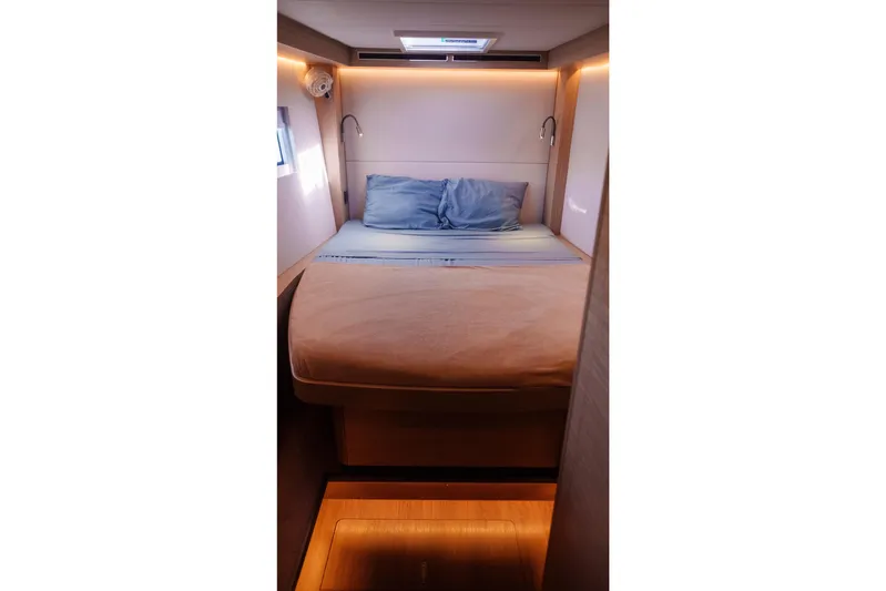 Bellissima Yacht Photos Pics 2024 Lagoon 51 yacht cabin with cozy bed and ambient lighting.