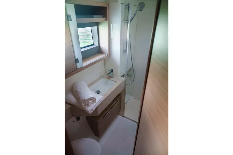 Bellissima Yacht Photos Pics 2024 Lagoon 51 yacht bathroom with modern sink, shower, and window view.