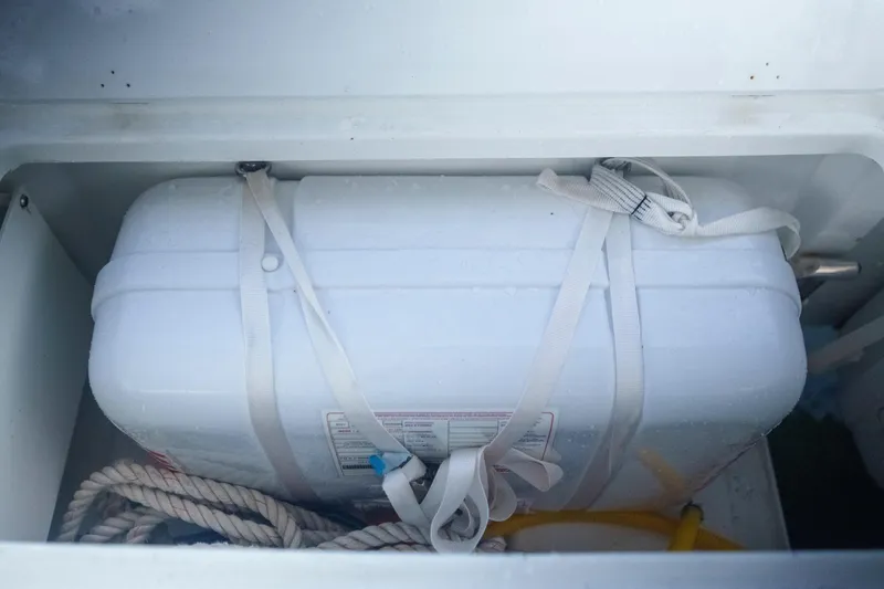 Bellissima Yacht Photos Pics Storage compartment on 2024 Lagoon 51 yacht with secured white container and rope.