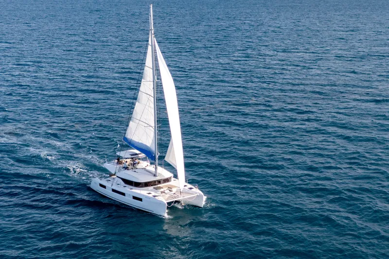 Bellissima Yacht Photos Pics 2024 Lagoon 51 catamaran sailing on open sea, showcasing sleek design and spacious deck.