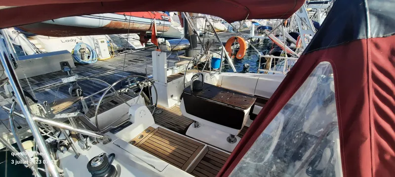  Yacht Photos Pics 2007 Elan Impression 434 yacht cockpit with wooden deck and red canopy.