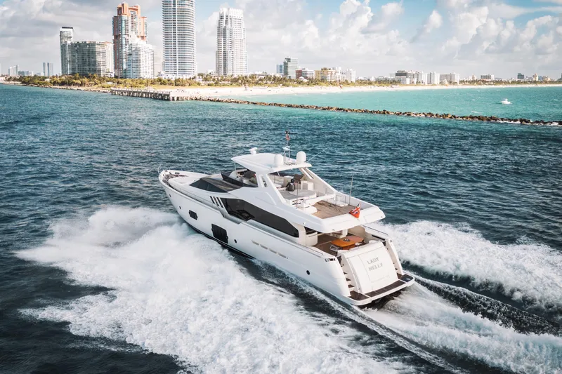 Lady Nelly Yacht Photos Pics Luxurious 2014 Ferretti Yachts 870 cruising near a vibrant city skyline.