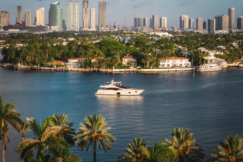 Lady Nelly Yacht Photos Pics Luxury 2014 Ferretti Yachts 870 cruising near a tropical city skyline.