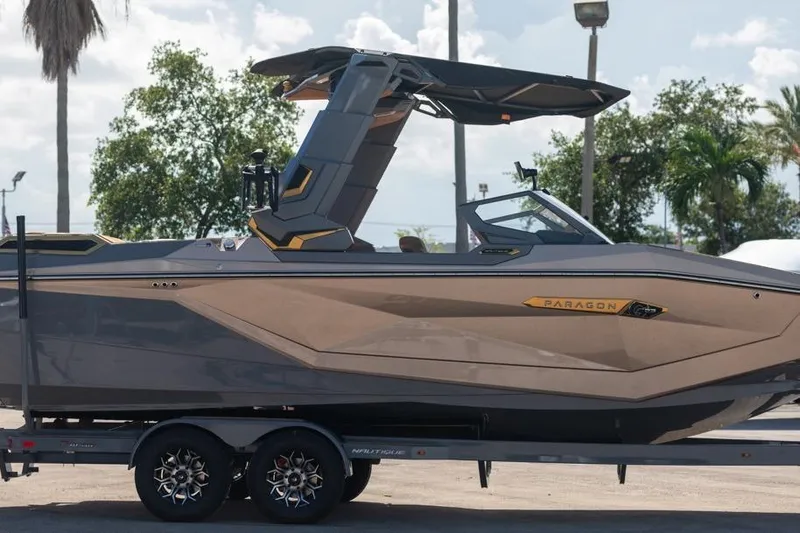  Yacht Photos Pics 2024 Nautique Super Air Nautique G23 Paragon boat on trailer, sleek design, outdoor setting.