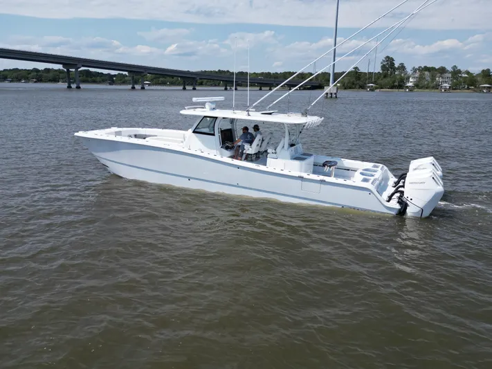  Yacht Photos Pics 2024 Freeman 43 boat cruising on a river with a bridge in the background.