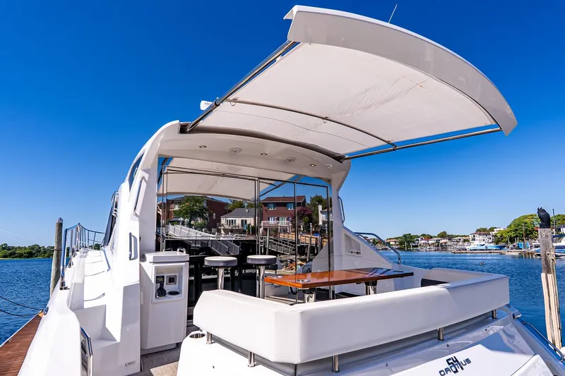 My Way Yacht Photos Pics 2019 Cruisers Yachts 54 Cantius luxury yacht docked, featuring spacious outdoor seating and canopy.