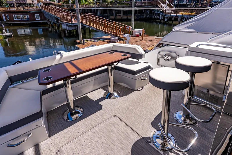 My Way Yacht Photos Pics 2019 Cruisers Yachts 54 Cantius cockpit with seating and table, dockside view.