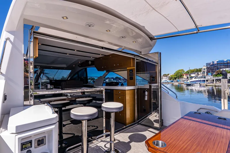 My Way Yacht Photos Pics 2019 Cruisers Yachts 54 Cantius luxury yacht interior with bar stools and marina view.