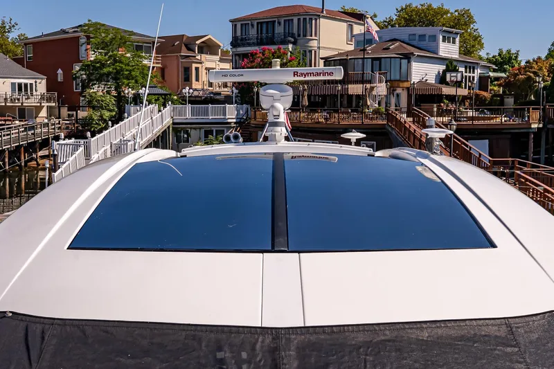 My Way Yacht Photos Pics 2019 Cruisers Yachts 54 Cantius docked near waterfront homes, featuring sleek design and Raymarine equipment.