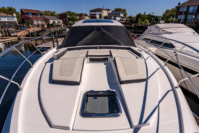 My Way Yacht Photos Pics 2019 Cruisers Yachts 54 Cantius with sun pads docked in a marina.