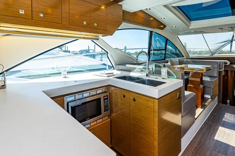 My Way Yacht Photos Pics Luxurious interior of 2019 Cruisers Yachts 54 Cantius with modern kitchen and seating area.